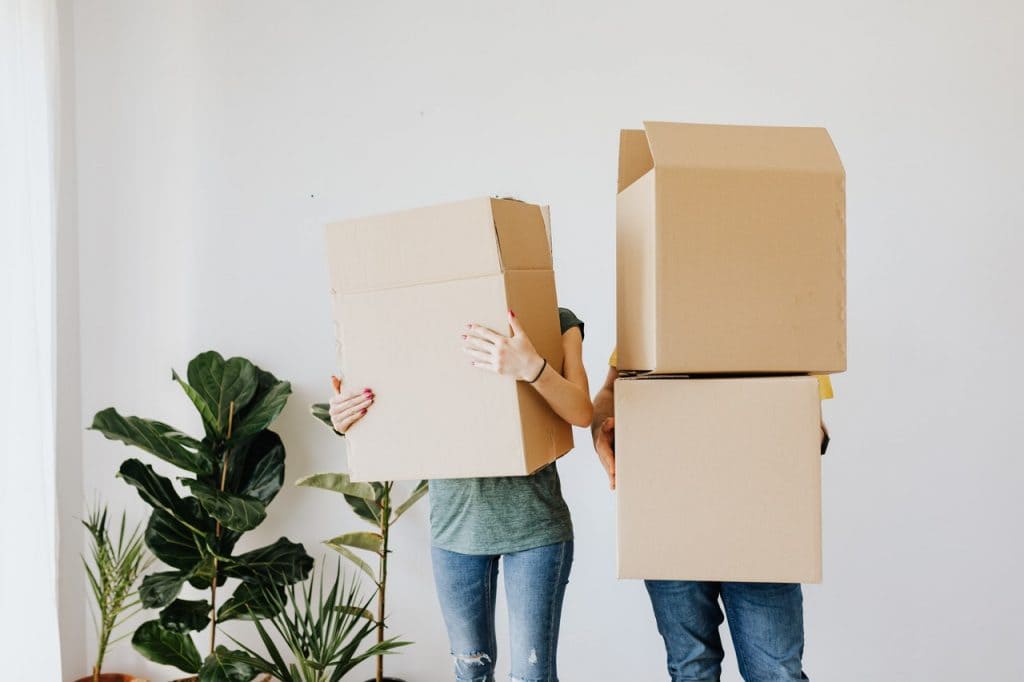 Couple holding moving boxes